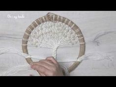 a person is making a tree decoration out of yarn