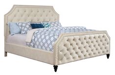 an upholstered bed with blue and white pillows on the headboard is shown