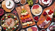 a table topped with lots of different types of cheeses and crackers on plates