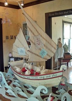 a model sailboat is on display in a room filled with other furniture and decorations