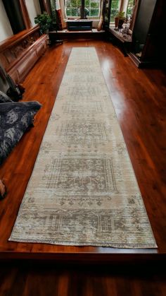 a large rug is on the floor in a room with wood floors and wooden windows