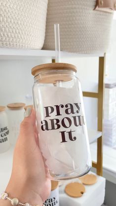 a person holding up a glass with the words pray about it