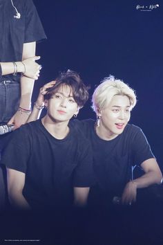 two young men sitting next to each other in front of a black background with the words bt