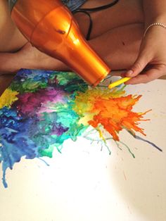 a person is using a hair dryer to blow out the colors on a painting