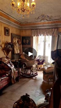 an old fashioned bedroom with antique furniture and paintings on the walls, along with a chandelier