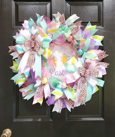 a colorful wreath is hanging on a door with the word easter written in front of it