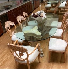 a glass dining table with chairs around it