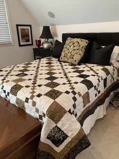 a bed with black and white quilt on it