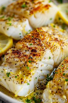 fish with lemon slices and herbs in a white dish