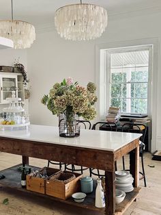 a kitchen with an island and chandelier hanging from the ceiling