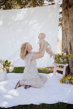 a woman holding a baby up in the air