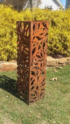 a tall metal sculpture sitting in the grass