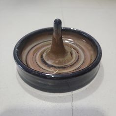 a brown and black bowl sitting on top of a white counter