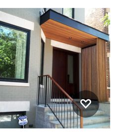 the front entrance to a home with stairs leading up to it and a heart - shaped window