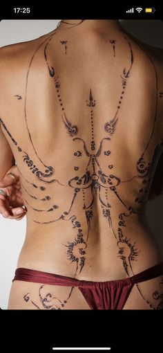 the back of a woman's body with tattoos on her chest and lower back