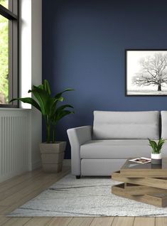 a living room with blue walls and a white couch in front of a coffee table