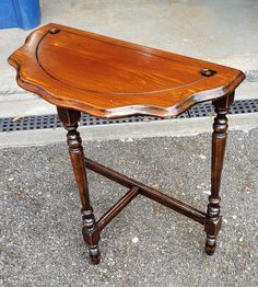 an old wooden table sitting on the sidewalk