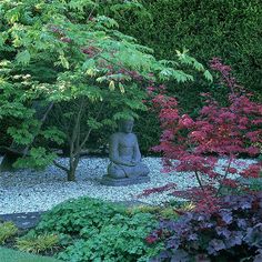 a buddha statue sitting in the middle of a garden