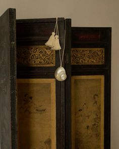 an old black cabinet with some tassels hanging from it