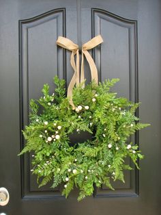 a green wreath hanging on the front door