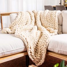 a large chunky blanket draped over a white couch