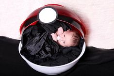 a baby is laying in a red and white bowl with black fabric on it's back