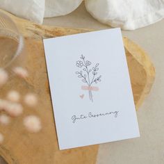 there is a card that has been placed on top of a wooden tray with flowers