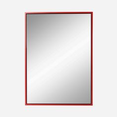 a red framed mirror on a white wall