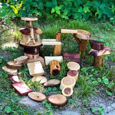 several pieces of wood sitting on the ground in front of some grass and trees with green leaves