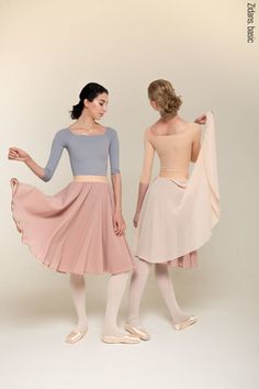 two women in ballet clothes standing next to each other