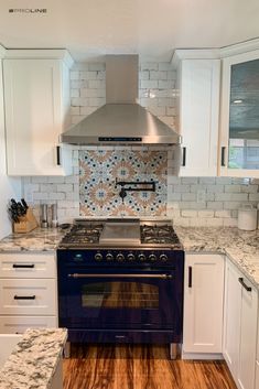 a stove top oven sitting inside of a kitchen next to white cabinets and counter tops