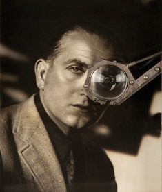 a black and white photo of a man with a magnifying glass in his hand