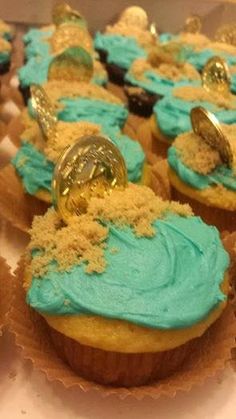 cupcakes with blue frosting and gold decorations