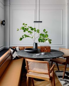 a dining room table with chairs and a potted plant on top of the table