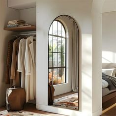 a bedroom with a large arched window next to a bed