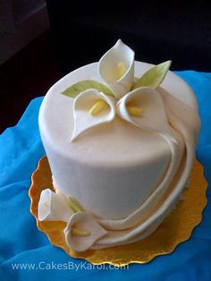 a cake with white frosting and flowers on it sitting on a blue table cloth