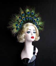 a mannequin wearing a black dress with peacock feathers on it's head