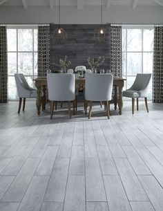 an image of a dining room with wood flooring on the walls and white chairs