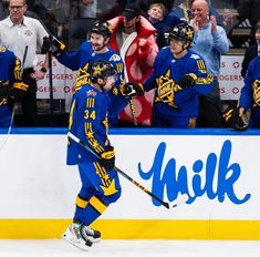 the hockey player is celebrating his goal in front of an excited crowd with his arms up