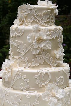 a three tiered wedding cake with white flowers