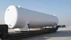 a large white tank on the back of a flatbed truck