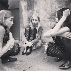 three women sitting on the ground talking to each other