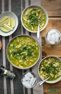 three bowls filled with soup on top of a table next to ice cubes and lemon wedges