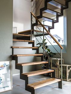 there is a stair case in the house with wood steps and metal railings on both sides