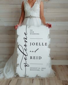 a woman in a wedding dress holding a sign with the words jolie and reid written on it