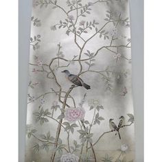 two birds sitting on a tree branch in front of a floral wallpaper with white flowers