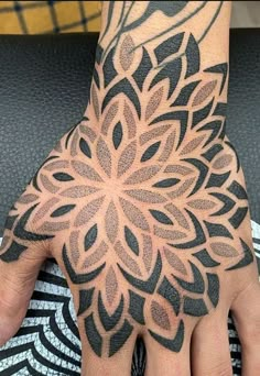 a person's hand with a tattoo on it and a flower design on the palm