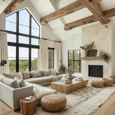 a living room filled with furniture and a fire place in front of a large window