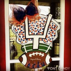 a football themed door hanger in the shape of a window with two bows on it