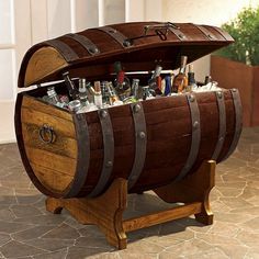 a wooden barrel filled with lots of bottles and liquor sitting on top of a table